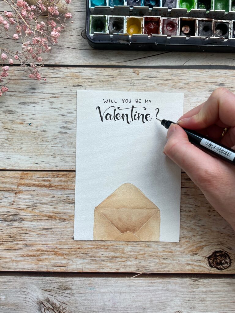 Eine Karte zum Valentinstag mit einem Briefumschlag und dem Spruch "Will you be my Valentine"