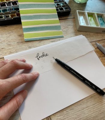 Sandra – Reingemalt – Aquarell malen lernen, einfache Letterings und DIY Grußkarten – Einfache Osterkarte mit Aquarell malen 7 Nun wird das, auf einem Schmierpapier vor skizzierte Lettering mit einem Fineliner auf das Transparentpapier übertragen.